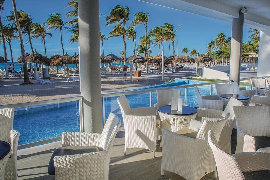 Poolside seating overlooking the beach at Hotel Riu Palace Antillas