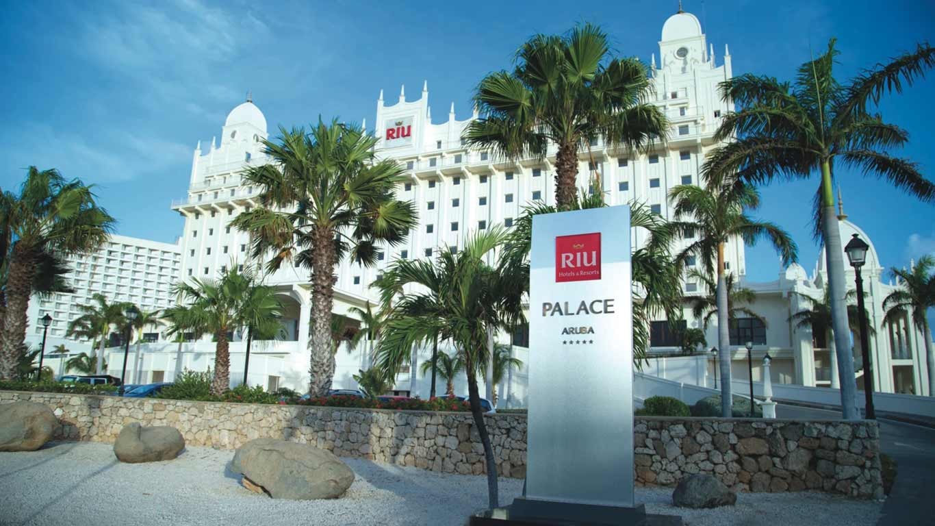 Riu Palace Aruba resort exterior with signage and palm trees